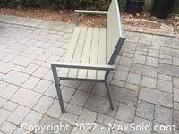 Side view of the vinyl seating outdoor bench on paved surface showing metal frame and vinyl slats