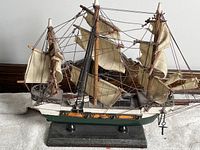Side view of Spanish ship model showing full sails and hull details mounted on wooden base
