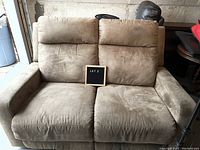 Front view of beige two seater Lazy Boy electric recliner couch in ultra suede with signs of use and soiling.