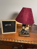 Vintage table lamp with burgundy fabric shade and ceramic base featuring two kittens on books.
