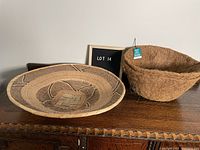Photo shows large woven basket with dark brown geometric pattern and two coconut fiber planter liners on a wooden surface.