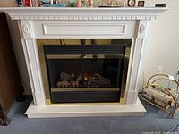 Front view of assembled electric fireplace and white wood surround showing black and brass trim insert.