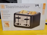 Front view of the Toastmaster 4-slice toaster box highlighting the brand name, image of toaster with bagels and bread slices, and key features including extra wide toast slots, high rise toast lift, adjustable shade control, bagel toasting function, and defrost function.