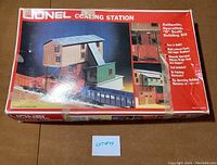 Box for Lionel Coaling Station showing full front with product images and branding, with damage and tape on box.