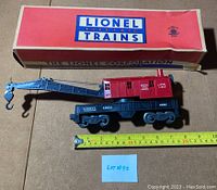 Lionel 6560 vintage Bucyrus Erie red cab crane car next to original box, with measuring tape showing about 9 inches length of crane car.