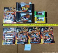 Lot of nine motorcycle models in original packaging, with ruler for size reference. Mixture of Jacks Deluxe and Hot Wheels brands.