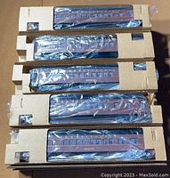 Five Williams Electric Train cars visible in cardboard trays wrapped in plastic showing Penn Tuscan brown color and window detailing.