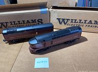 Two Pennsylvania diesel locomotives in front of their Williams Electric Trains boxes