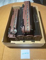 Five passenger train cars in maroon with black roofs arranged inside a box showing condition and arrangement.