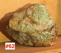 Front angled view showing turquoise green patches on mainly brown and beige matrix stone.