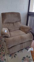 Front and side views of the brown upholstered Flexsteel recliner chair showing cushioned armrests, textured fabric, and padded backrest.