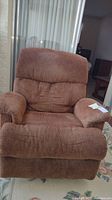 Front view of brown upholstered Flexsteel rocker recliner showing cushioned backrest, armrests and seat.