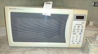 Front view of Sharp Carousel microwave oven showing door with window and control panel on the right side