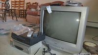 Side angled photo of the Sanyo 29-inch analog CRT TV with two VCRs and remotes placed around it.
