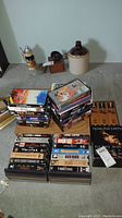 Photo showing stacks of twenty-four VHS tapes with storage, titles visible including Close Encounters, Erin Brockovich, Fail Safe, etc.