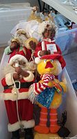 Bin containing the Santa Claus, Mrs. Claus, Big Bird, and Pop animated figures all plugged in and placed together.