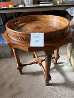 Full view of wooden butler side table with removable round tray showing decorative inlay and turned legs on carpeted floor.