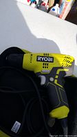 Side profile of yellow and black Ryobi electric corded drill.