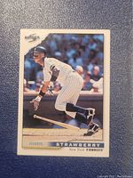 Front view of Darryl Strawberry baseball card in Yankees uniform showing batting pose with bat on ground