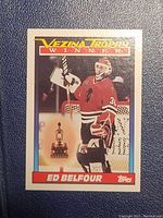 Front side of the Ed Belfour Vezina Trophy Winner Topps hockey card showing Belfour in goalie uniform and trophy image.