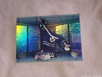 High grade holographic foil hockey card featuring Curtis Joseph in Toronto Maple Leafs uniform, embossed and with blue shiny background, approx 3 inch size.