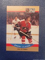 Front of Bobby Clarke Pro Set hockey card showing player in Philadelphia Flyers uniform with captain patch and Hall of Famer title.