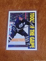 Front of Doug Gilmour Tools of the Game hockey card, showing him in action on the ice in Toronto Maple Leafs uniform with team colors and the card series title in yellow letters.