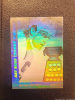 Front view of holographic card showing Wayne Gretzky and the Art Ross Trophy with visible holographic shine and text details.