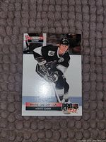 Front of Wayne Gretzky Pro Set Assists Leader card showing him skating in a black and white uniform with statistical leader label.