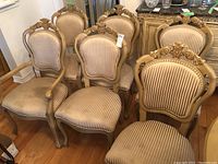 Six vintage wood frame dining chairs shown together, four without arms and two with arms, beige vertical striped upholstery