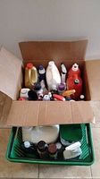 Open box view showing multiple cleaning product bottles in various sizes and colors packed together.