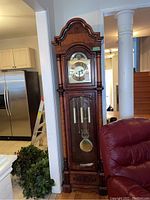 Full front view of clock showing overall design and pendulum