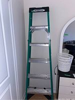 Full view of the Werner 6-foot aluminum step ladder showing green side rails, wide steps, and black top platform.