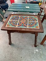 Small table with mosaic ceramic tile top and wooden frame with turned legs