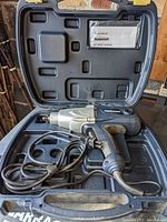 Mastercraft 1/2 inch impact wrench inside a hard black carrying case with the power cord coiled, showing the tool and interior case layout.