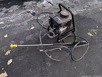 Full view of the Craftsman gas pressure washer with the lance and hose laid on the ground.