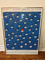 Framed art exhibit poster showing repeated blue figures and one red-hatted figure, dated 1972 for an exhibit in Bordeaux.