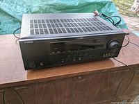 Front and top view of Yamaha AV receiver showing overall condition and dent on top left corner.