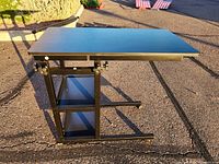 Full view of adjustable height rolling desk with sturdy black metal frame and side shelves.