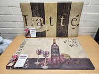 Two kitchen anti-fatigue floor mats laid on a table showing coffee and wine themes, with tags indicating 'Code-N Comfort'.