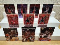 Lot of 11 Michael Jordan basketball cards arranged in two rows on a display stand showing various action shots and designs including red and purple backgrounds.