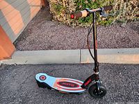Front side view of black Razor Electric Scooter E100 on pavement showing handlebar, deck with logos, front wheel.