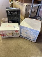 Photo showing the boxed 41 piece kitchen set with counter block by Element, boxed 6 piece Alfresco acrylic drinkware set, and boxed 20 piece Fairfield fine china Jamestown dinnerware set for 4.