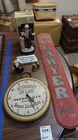 Overview of all items in the lawyer memorabilia lot including wall sign, clock, and figurines
