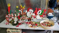 Wide view of table with foam bead wall hangings at rear and assorted decorations in front