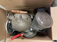 Box containing the tea kettle, sifters, meat grinder, egg slicer, and measuring cups showing all items packed together.