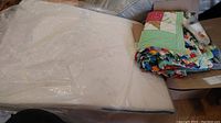 Quilted wedge pillow wrapped in protective plastic, angled view