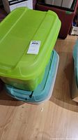 Green translucent tote and light blue tote stacked, closed.