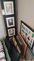 Full view of folding photo screen and various frames stacked on floor