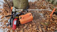 Overview of all four items together on ground covered with dry leaves near a tree trunk.